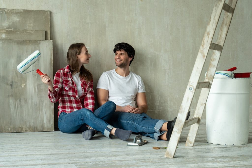 happy family couple relaxing after painting young couple lying floor tips cash house sale